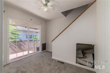 unfurnished living room featuring light colored carpet and ceiling fan