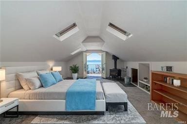 bedroom featuring a wood stove, dark carpet, and lofted ceiling