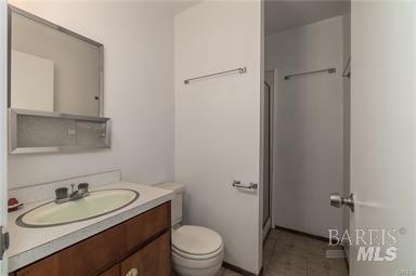 bathroom featuring vanity, an enclosed shower, and toilet