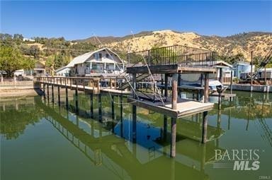 view of dock with a water and mountain view