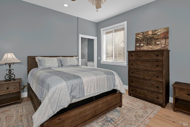 bedroom with connected bathroom, ceiling fan, and light wood-type flooring