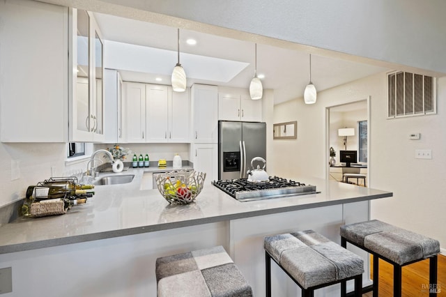 kitchen with white cabinetry, sink, kitchen peninsula, and stainless steel appliances