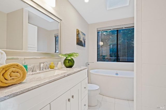 full bath with tile patterned floors, a bathing tub, toilet, and vanity