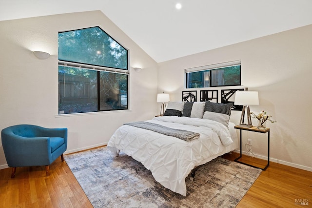 bedroom with hardwood / wood-style flooring and lofted ceiling