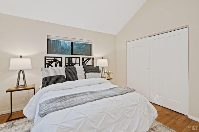 bedroom with light hardwood / wood-style floors, a closet, and lofted ceiling