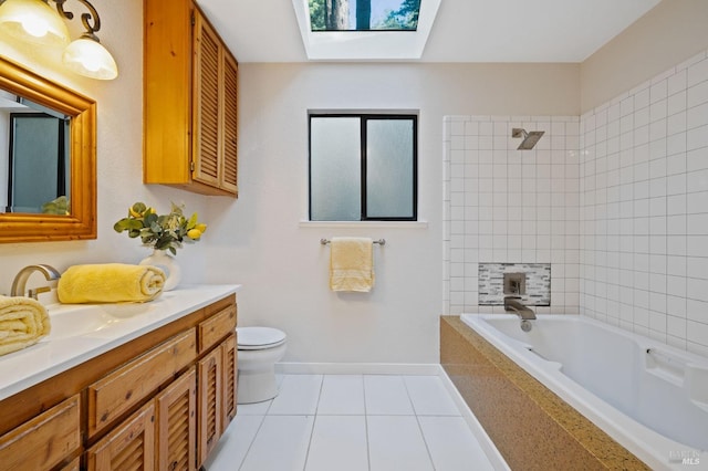 full bathroom with a skylight, tiled shower / bath combo, tile patterned flooring, toilet, and vanity