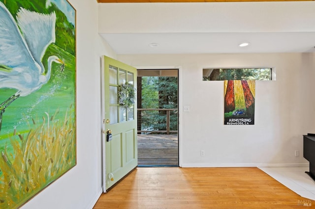 doorway to outside with a wealth of natural light, light wood-type flooring, and baseboards