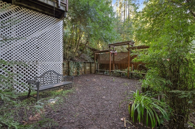 view of yard with a pergola and fence