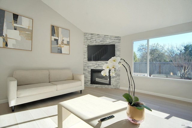 living room with a fireplace, plenty of natural light, and lofted ceiling