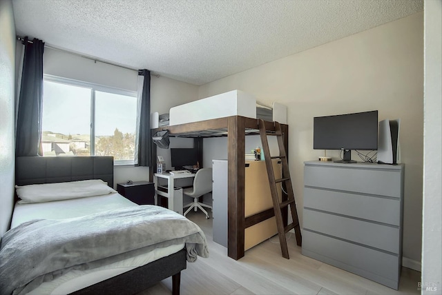 bedroom featuring light wood-type flooring and a textured ceiling