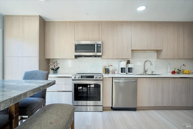 kitchen with appliances with stainless steel finishes and light brown cabinetry