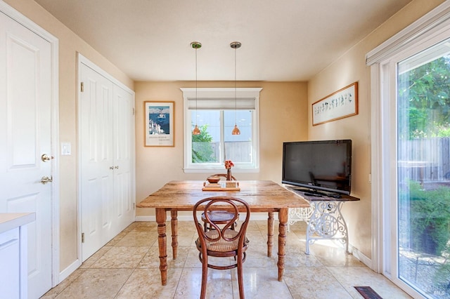 dining area with a healthy amount of sunlight, visible vents, and baseboards