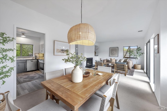 dining space featuring light colored carpet and plenty of natural light