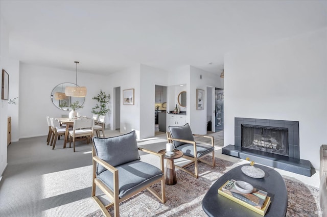 carpeted living room with a tile fireplace