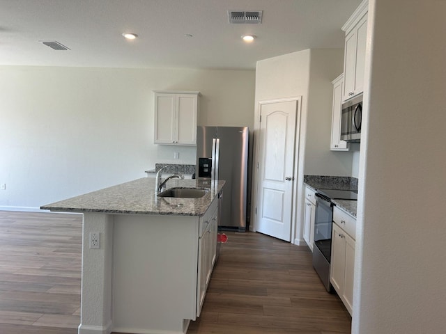 kitchen with stainless steel appliances, dark wood-style flooring, visible vents, and a sink