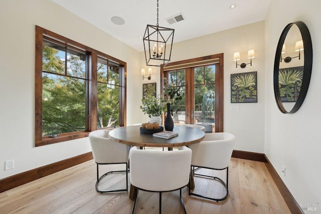 dining room featuring light wood finished floors, plenty of natural light, and visible vents