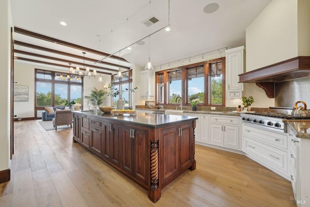 kitchen featuring stainless steel gas cooktop, visible vents, white cabinets, light wood-type flooring, and decorative light fixtures