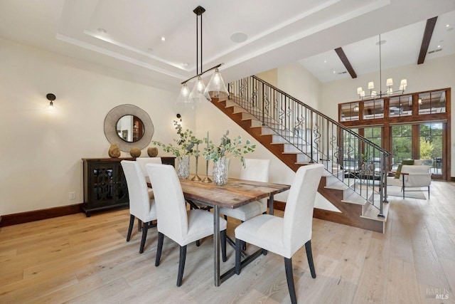 dining area featuring stairway, light wood-type flooring, and an inviting chandelier