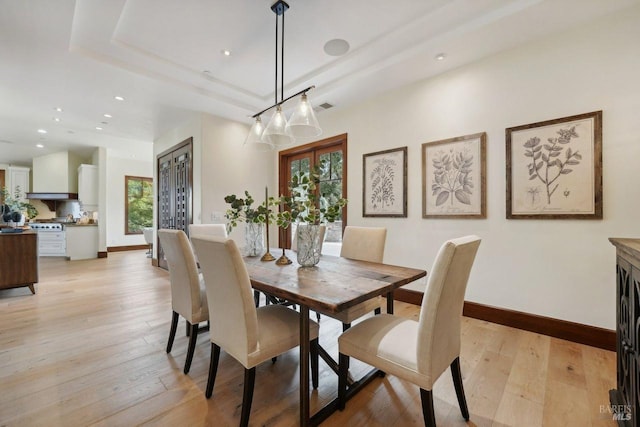 dining space featuring visible vents, baseboards, a raised ceiling, light wood-style flooring, and recessed lighting