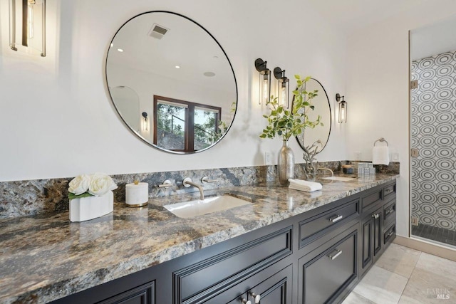 bathroom with visible vents, a sink, and double vanity