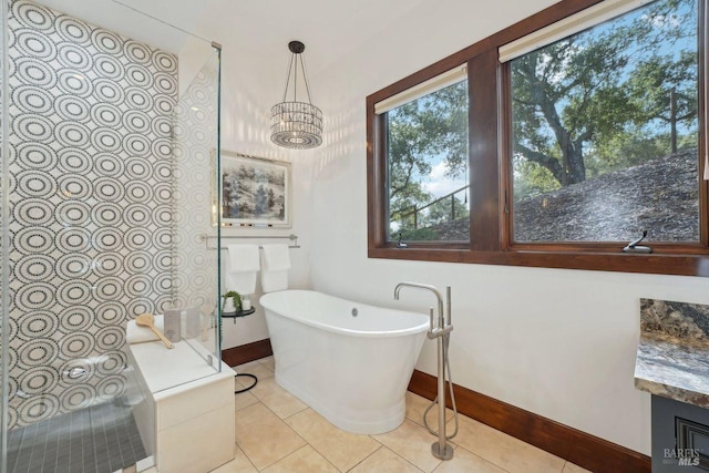 full bathroom featuring a chandelier, tile patterned flooring, a soaking tub, and vanity