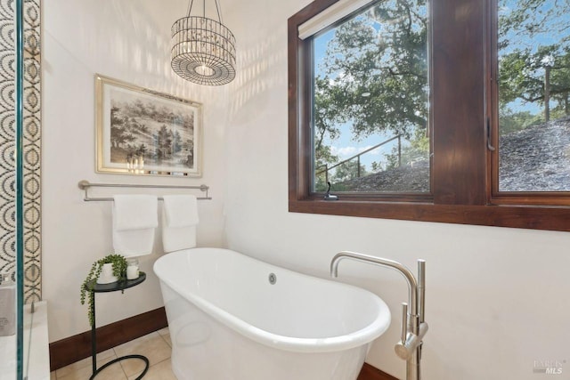 full bathroom featuring baseboards, a freestanding bath, and tile patterned floors