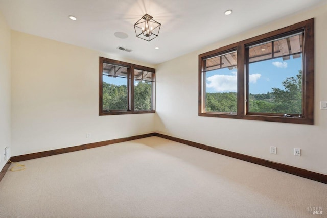 empty room with carpet, recessed lighting, visible vents, a chandelier, and baseboards