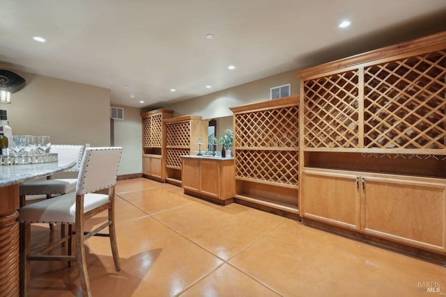 wine cellar featuring a bar, light tile patterned floors, visible vents, and recessed lighting