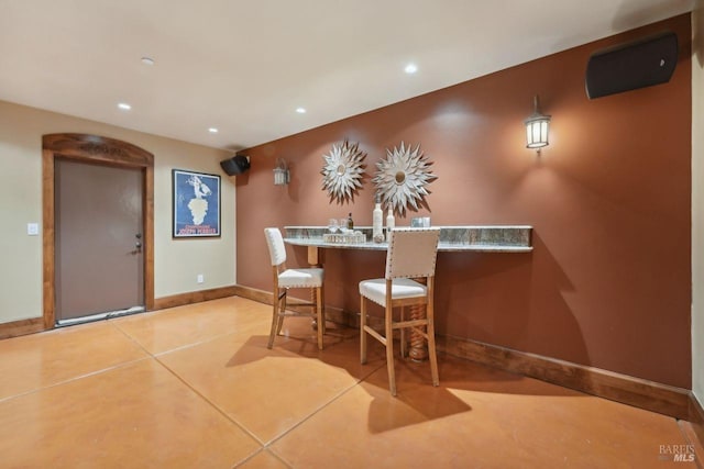 interior space with baseboards, indoor wet bar, and recessed lighting