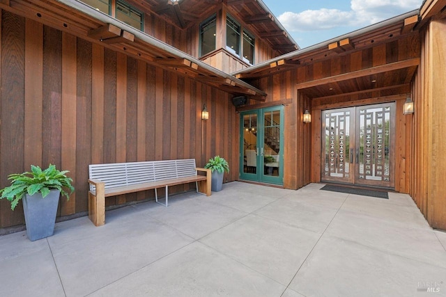 view of exterior entry featuring french doors and a patio area