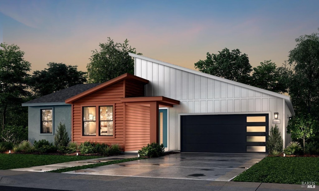 contemporary home featuring driveway, an attached garage, and board and batten siding