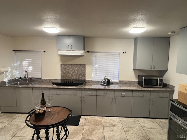 kitchen featuring sink, gray cabinetry, and a textured ceiling