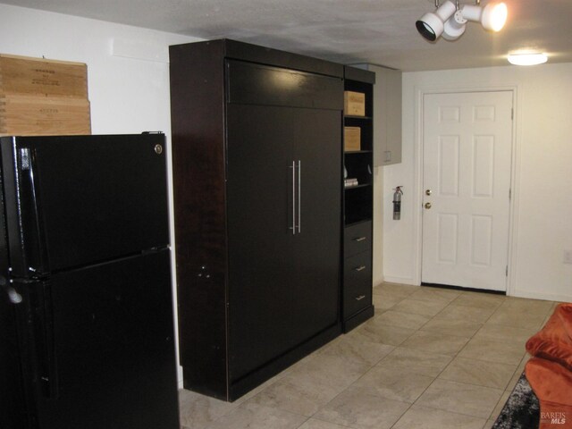 kitchen with sink, built in refrigerator, white cabinets, and black refrigerator