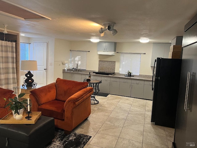 kitchen featuring sink, white cabinetry, black appliances, and light tile patterned flooring