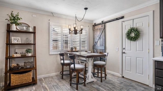 dining room featuring a barn door, crown molding, wood-type flooring, and an inviting chandelier