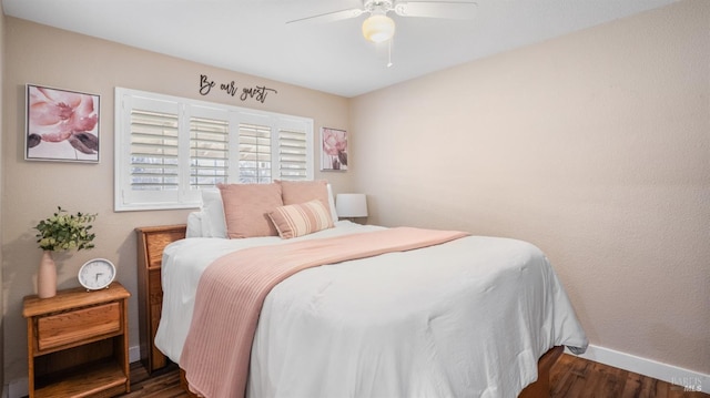 bedroom with dark hardwood / wood-style flooring and ceiling fan