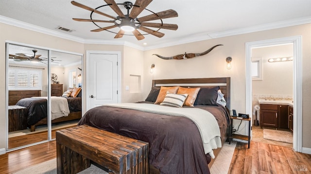 bedroom featuring ceiling fan, light hardwood / wood-style floors, crown molding, and connected bathroom