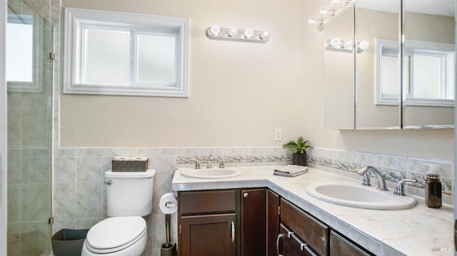 bathroom with vanity, tile walls, toilet, and walk in shower