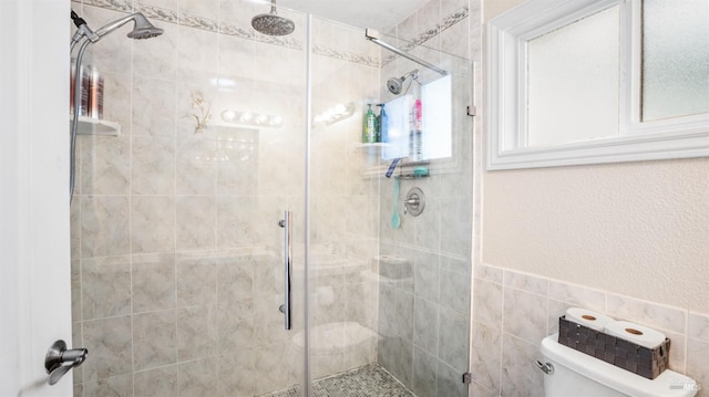 bathroom featuring toilet, tile walls, and an enclosed shower