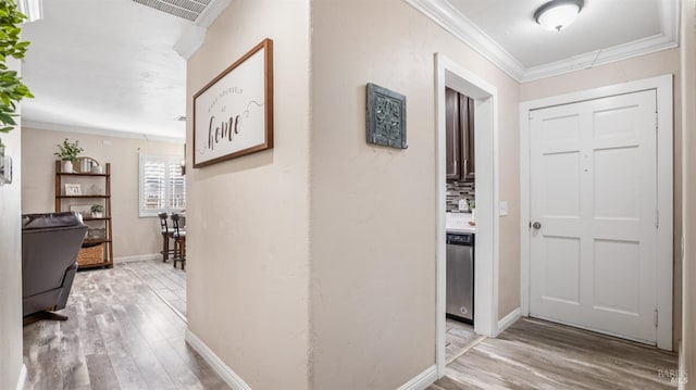 foyer entrance with light hardwood / wood-style flooring and ornamental molding