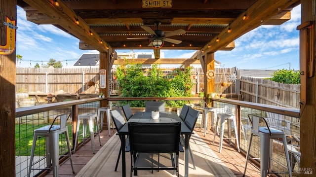 wooden terrace with ceiling fan and a bar