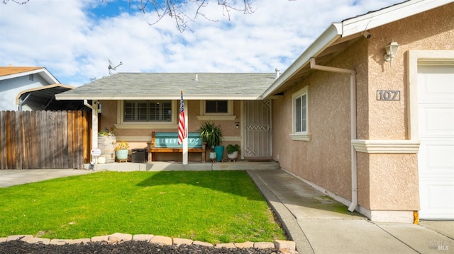 view of exterior entry with a yard and a garage