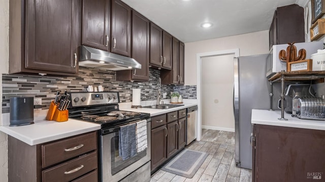 kitchen featuring dark brown cabinetry, appliances with stainless steel finishes, sink, and tasteful backsplash