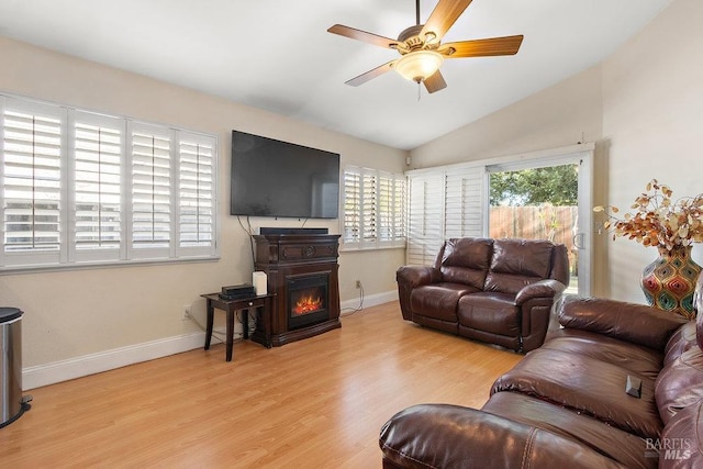 living room with ceiling fan, light hardwood / wood-style floors, and lofted ceiling