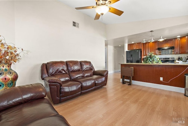 living room featuring light wood-type flooring, high vaulted ceiling, and ceiling fan