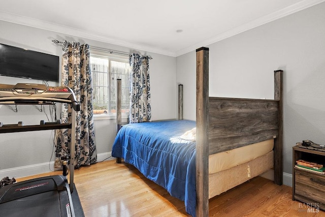 bedroom with hardwood / wood-style flooring and crown molding