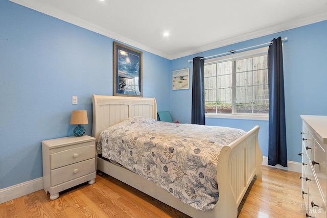 bedroom with crown molding and light hardwood / wood-style flooring