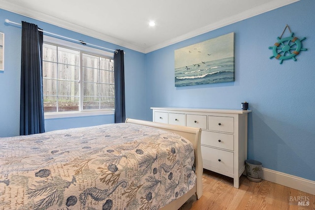 bedroom featuring light wood-type flooring and crown molding