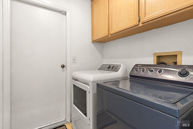 washroom with washing machine and dryer and cabinets