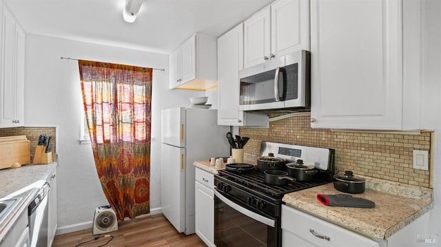 kitchen featuring decorative backsplash, appliances with stainless steel finishes, white cabinets, and light hardwood / wood-style flooring